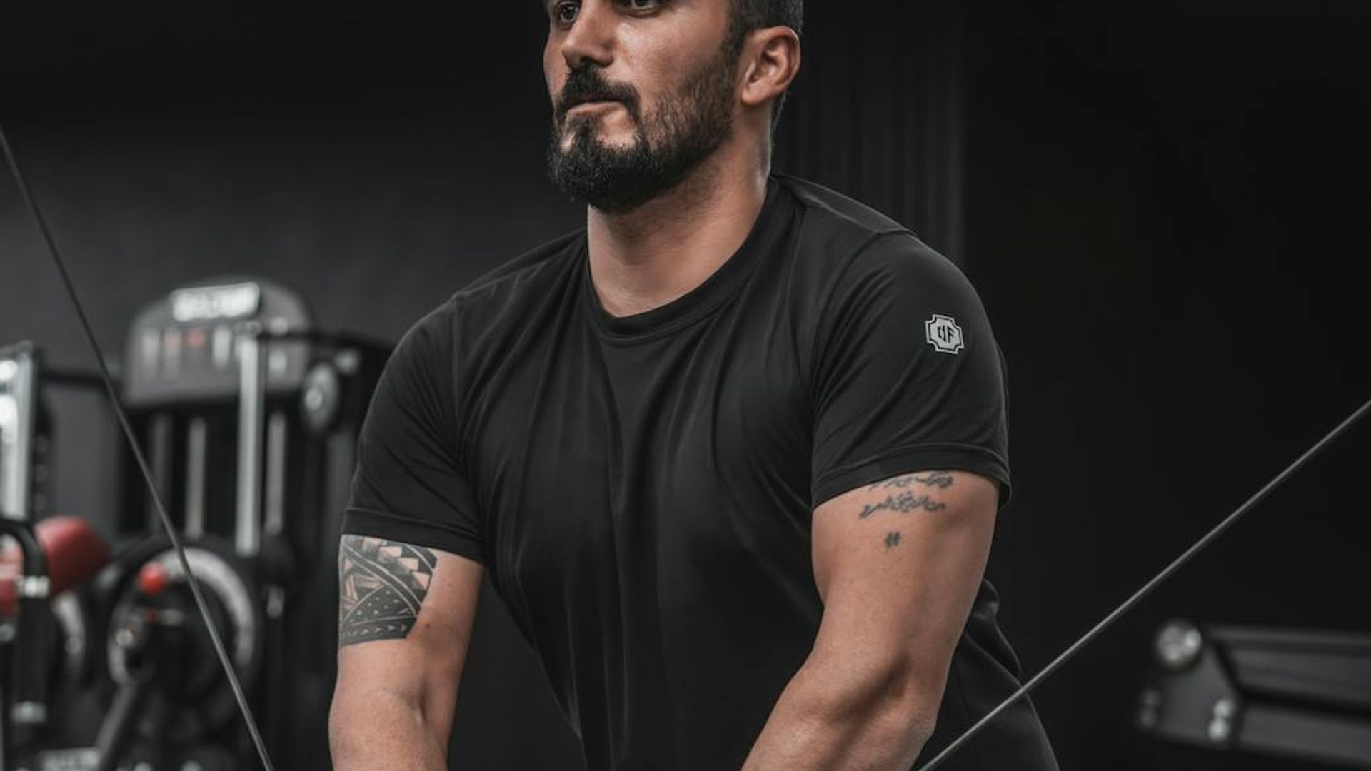 Determined man focused on his training routine in a dark gym.