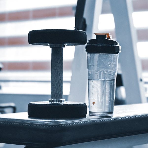 Sports bottle and towel on a bench in the gym.